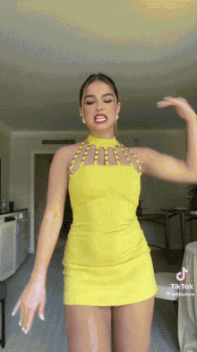 a woman in a yellow dress dancing in a room