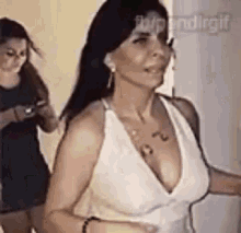 a woman in a white dress with a plunging neckline is dancing in a room .