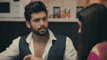 a man with a beard talks to a woman
