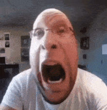 a man in a white shirt is making a funny face with his mouth open .
