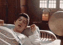a man in a white shirt is laying in a chair with his eyes closed