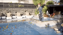 a man jumps into a swimming pool with a sign that says shall break