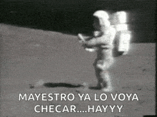 a black and white photo of a man in a space suit walking on the moon .