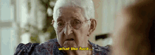 an elderly woman with glasses is making a funny face and says what the fuck .