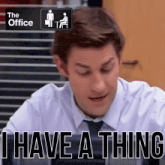 a man sitting at a desk with the words " i have a thing " in front of him