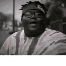 a man wearing glasses and a headband with the word supreme on it is making a funny face .