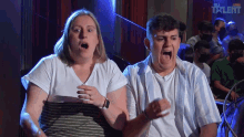 a man and a woman are screaming in front of a crowd with the word talent behind them