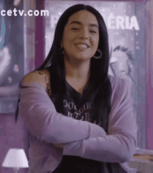 a woman wearing a purple cardigan and a black shirt that says do girl wear