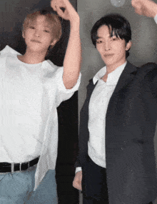 a man in a white shirt and a man in a suit are standing next to each other