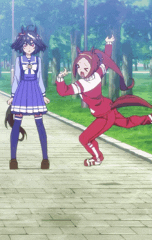 a girl in a blue dress is standing next to a girl in a red jacket