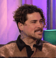 a man with curly hair and a beard has a tattoo on his face that says whale