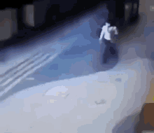 a man in a white shirt is walking down the street .