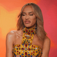 a woman wearing a yellow top with rhinestones on it making a face