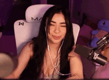 a woman is sitting in a chair with a microphone and headphones .