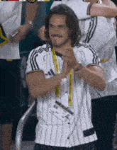a man wearing a white and black striped shirt is clapping his hands .