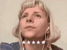 a woman wearing ear buds has five stars surrounding her neck