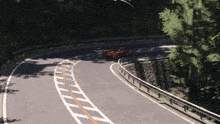 a red car with the number 5 on the side is driving down a road