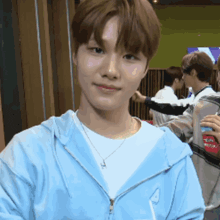 a young man wearing a light blue hoodie and a white t-shirt