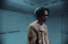 a person covering their face with their hands in a dark room .