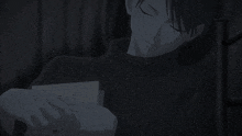 a man in a black shirt is reading a piece of paper