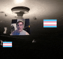 a picture of a man with a pink white and blue transgender flag behind him