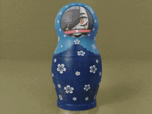 a blue green and orange russian nesting doll with a girl on it