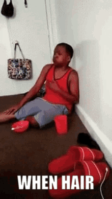 a person is sitting on the floor with slippers and a sign that says " when hair " on it