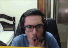 a man wearing headphones and glasses looks surprised