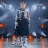 a girl in a sailor outfit is standing on a stage with a microphone
