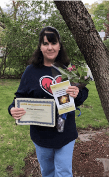 a woman holding a certificate that says nurse excellence award on it