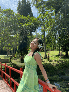 a woman in a green dress with a white flower in her hair