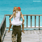 a man carrying a woman on his shoulders with the words colucciyarango_ on the bottom