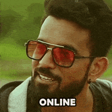 a man with a beard wearing red sunglasses and the word online below him