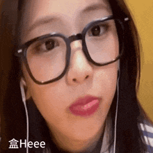 a close up of a woman wearing glasses and ear buds .