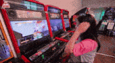 a woman is playing a video game in an amusement center
