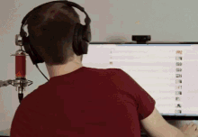 a man wearing headphones is sitting in front of a computer screen