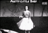 a woman in a white dress is dancing in front of a ferris wheel and the words " pretty little baby " above her