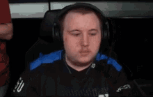 a man is sitting in a chair wearing headphones and playing a video game .