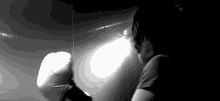 a black and white photo of a person holding a pillow