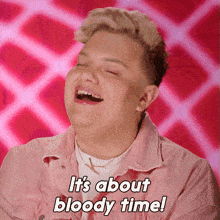 a man in a pink jacket is laughing with the words it 's about bloody time