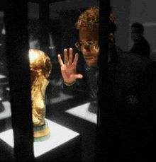 a man looking at a trophy in a display case