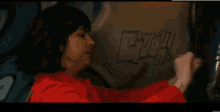 a woman in a red jacket is writing on a wall that says efh