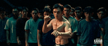 a group of young men are standing in a dark room with the word kahar on the bottom
