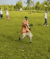 a person in an orange jacket is running in a field .