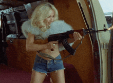 a woman in shorts holds a gun in her hand