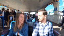 a man and a woman are sitting on a roller coaster with a sign that says no smoking