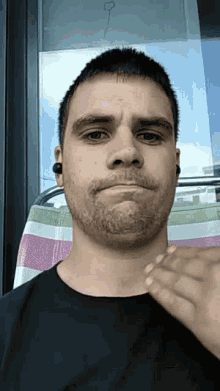 a man with a beard and ear plugs is making a funny face