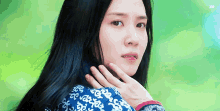 a close up of a woman 's face with a hand on her face