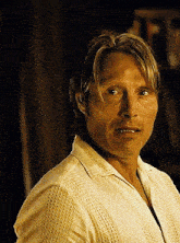 a man in a yellow shirt looks at the camera
