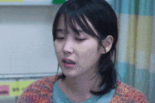 a close up of a woman 's face with a sweater on